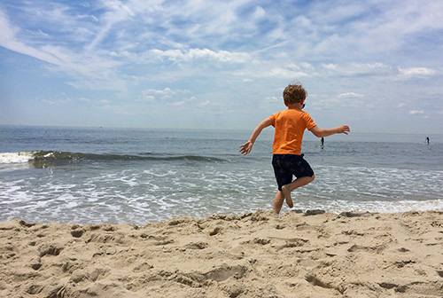 A boy leaping on the beach