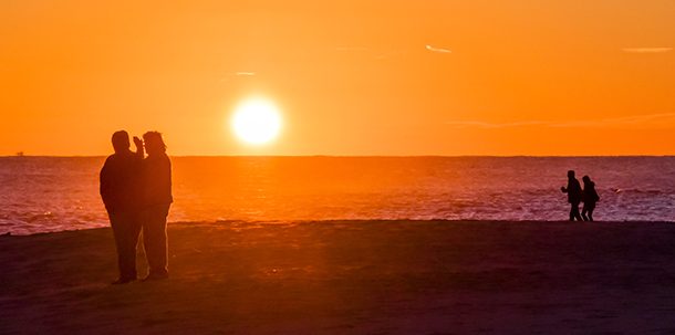 Couples in silhouette on the beach in Cape May - Photo by Laura Thistle