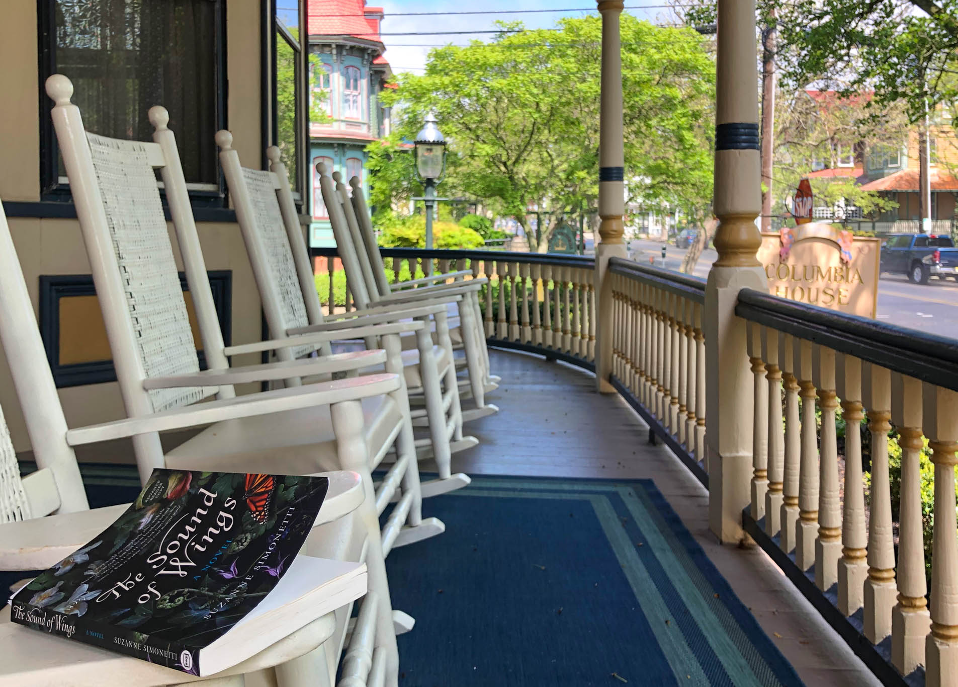 sitting on the Columbia House porch with the book The Sound Of Wings