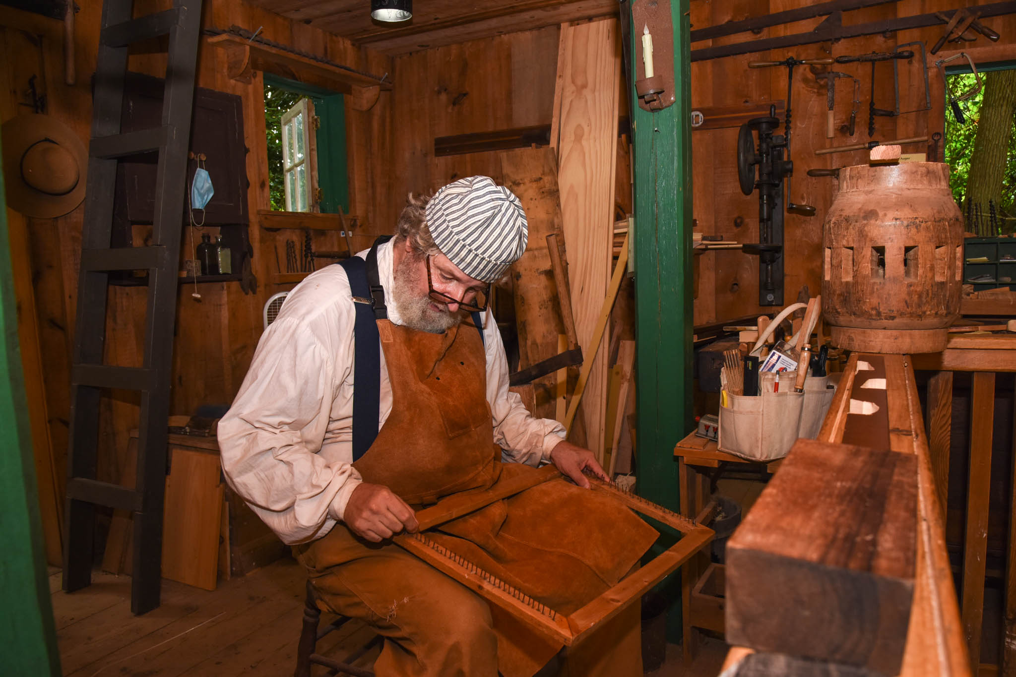 A woodworker demonstrates how things are made at the Woodworking shop. This was built in 1900 Historic Cold Spring Village