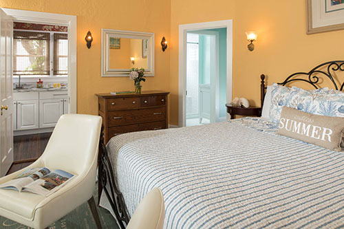 Guest room with sunny yellow walls and a striped bedspread