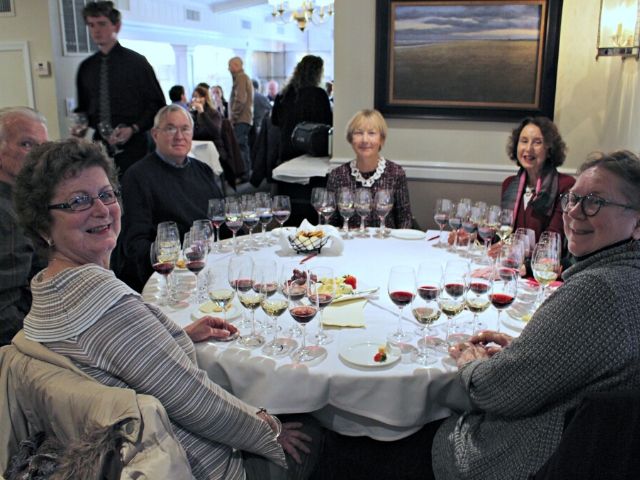 People seated around a table tasting wine