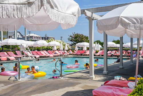 People with colorful floats in the outdoor swimming pool at Congress Hall