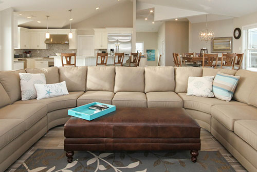 Tan sofa and dark brown leather ottoman with teal serving tray