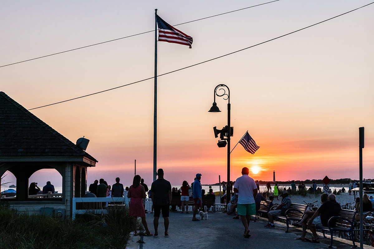 People gathered at the end of the promenade watching sunset