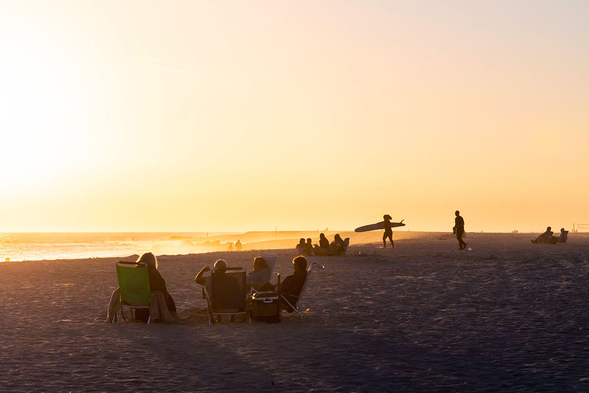 People sitting on the beach during golden hour