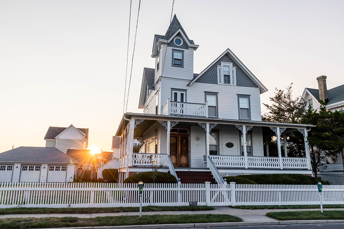 Sun setting behind a Victorian house