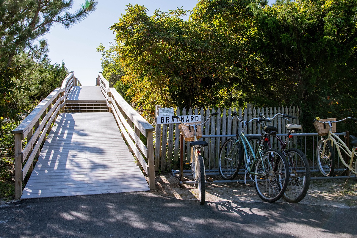 Bikes parked at a path to the beach on a sunny day