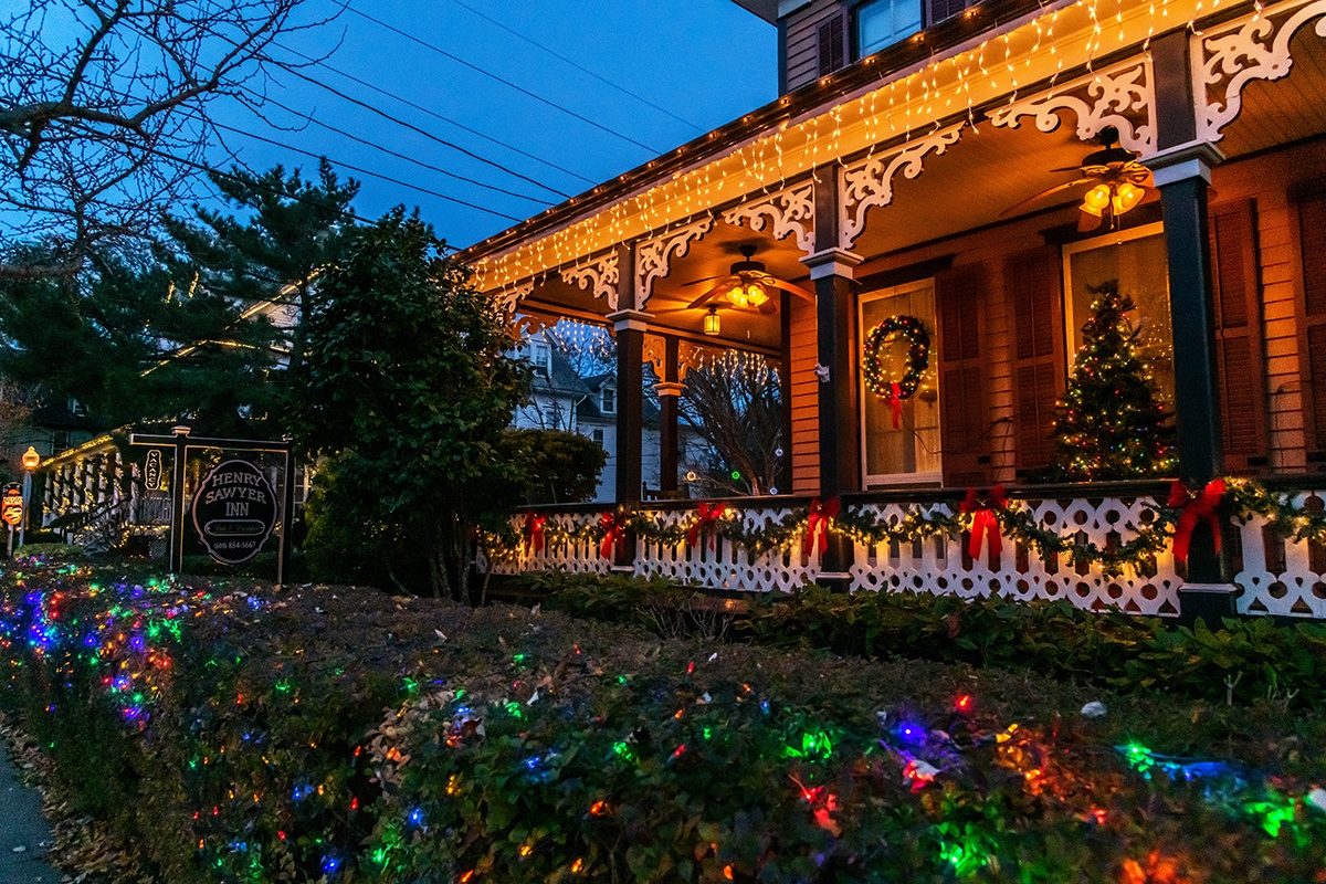 Christmas lights and decorations on a porch of a Victorian style house