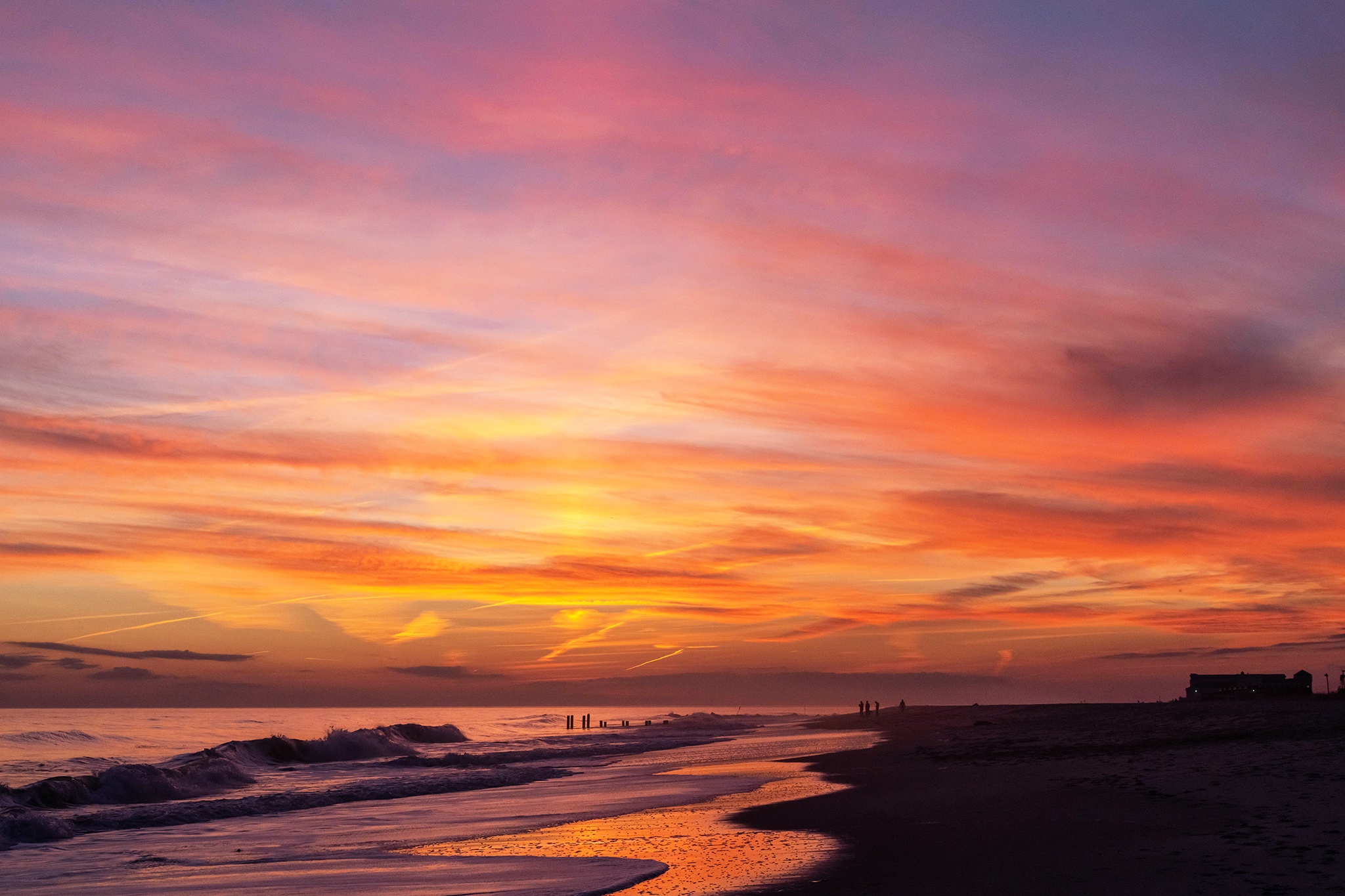 Pink, blue, orange, and yellow colors in the sky after sunset at the beach