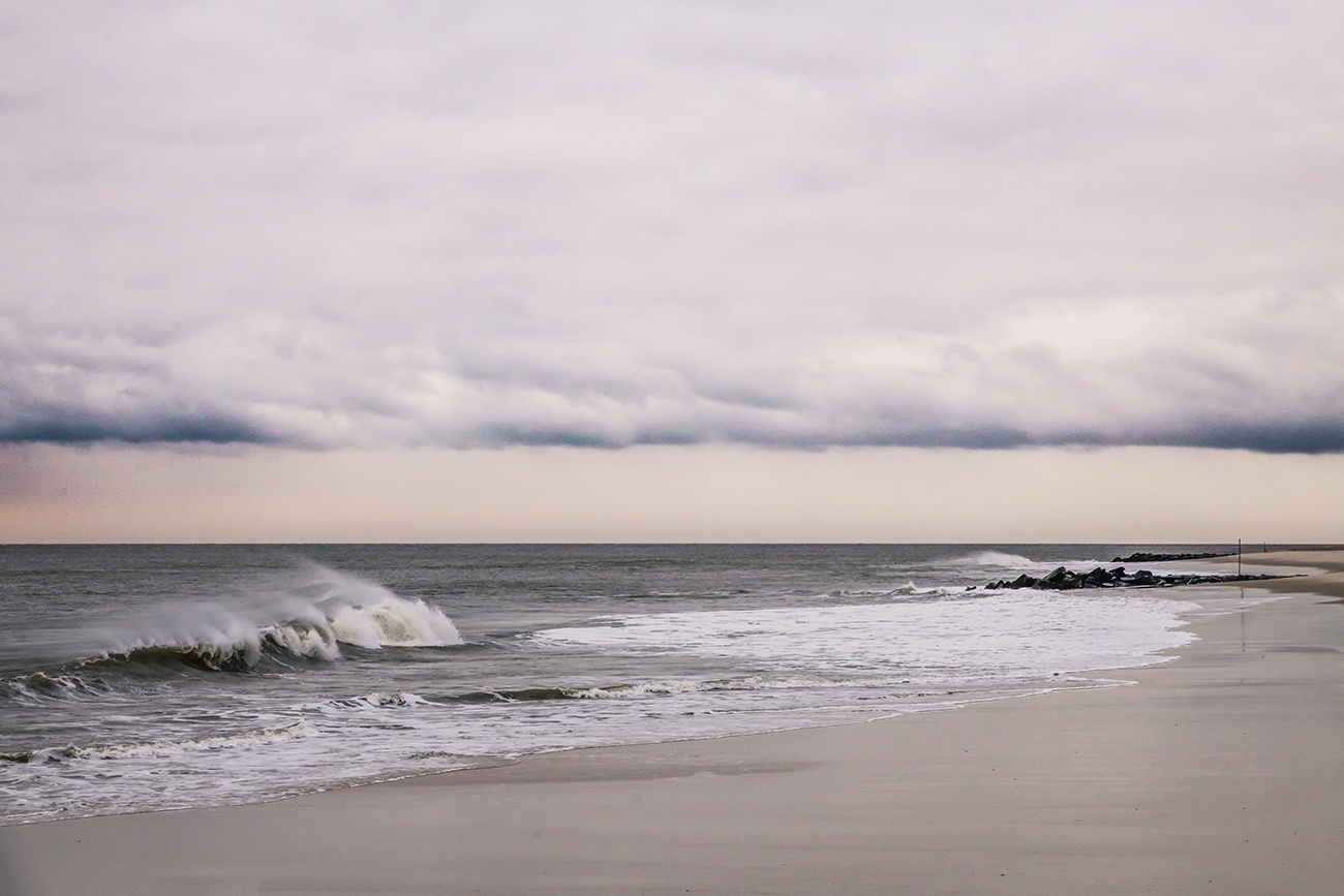 Cloudy skies and rough waves crashing at the beach