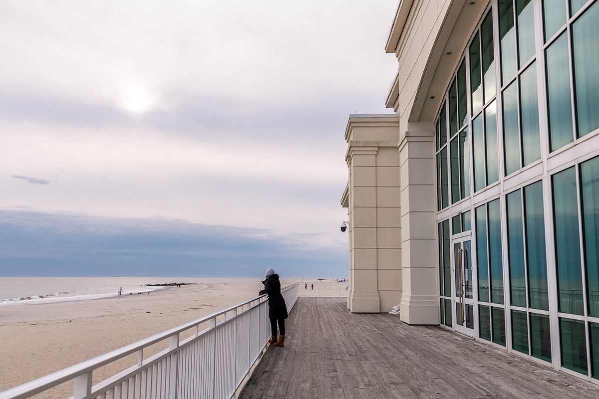 A person looking at the clouds and the beach on the deck at Convention Hall