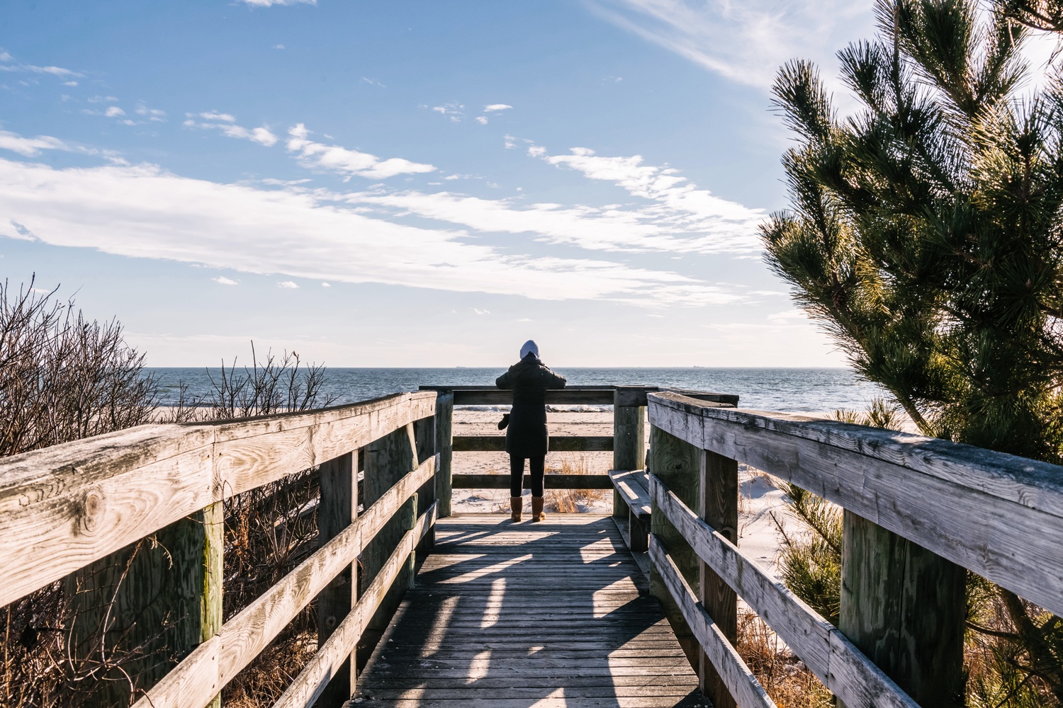 A person looking at the beach and ocean on a sunny day