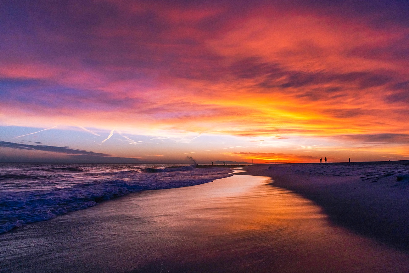 Colorful clouds in the sky at sunset by the ocean on the beach