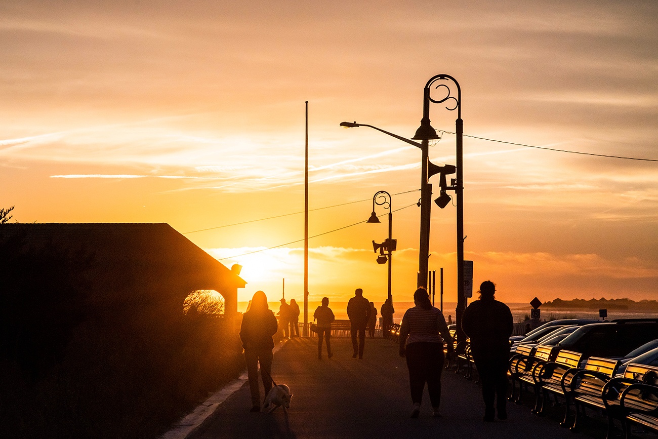 People walking on the promenade at sunset