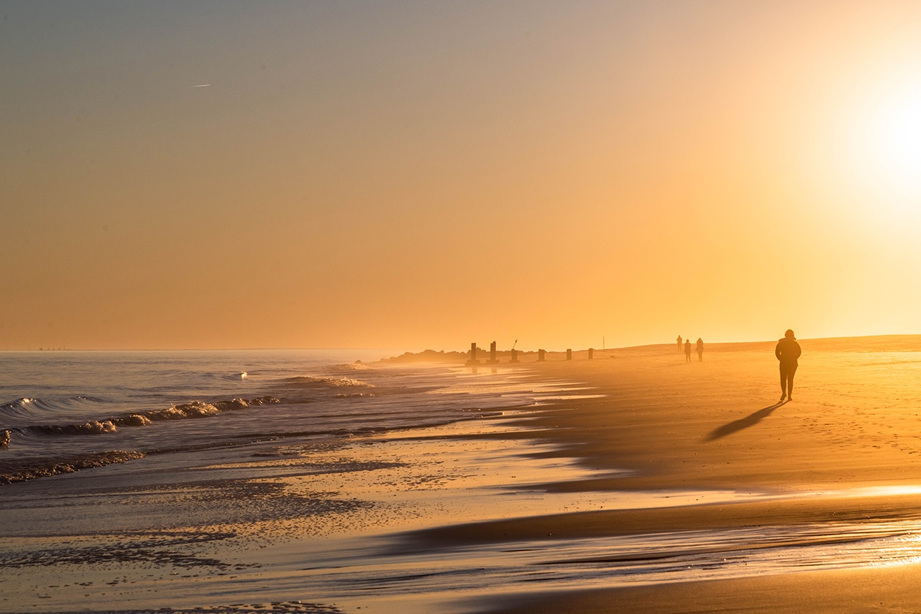 People walking on the beach at sunset