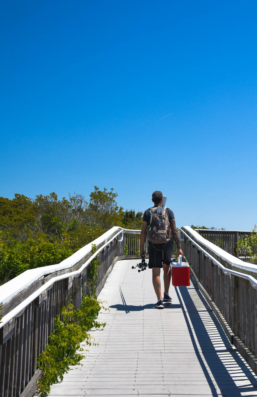 Man holding fishing gear on a Friday heading to Poverty Beach