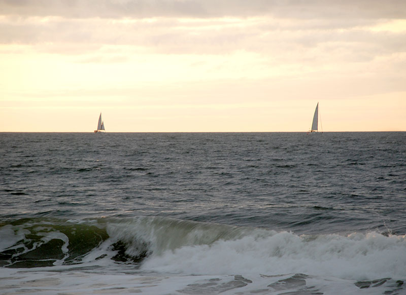 Two sailboats on the horizon