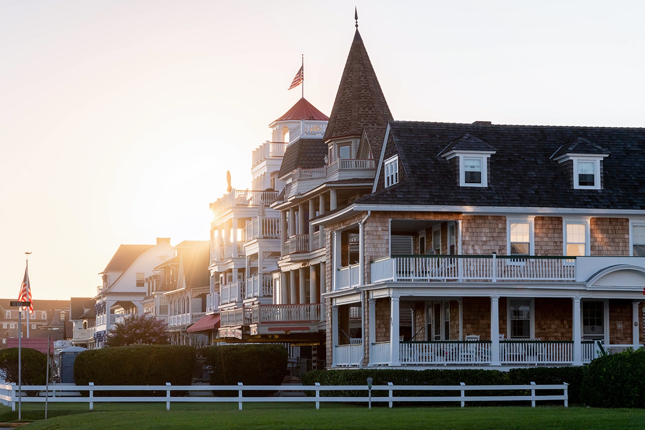 The sun shining and setting behind Victorian houses 