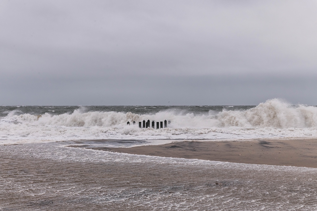 Waves crashing with extreme high tides on a stormy gray day