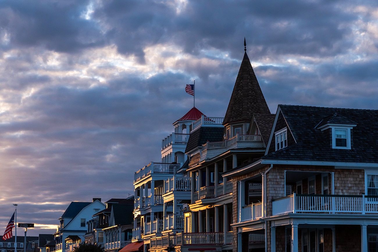 Sunlight shining on Victorian houses at sunset with clouds in the sky