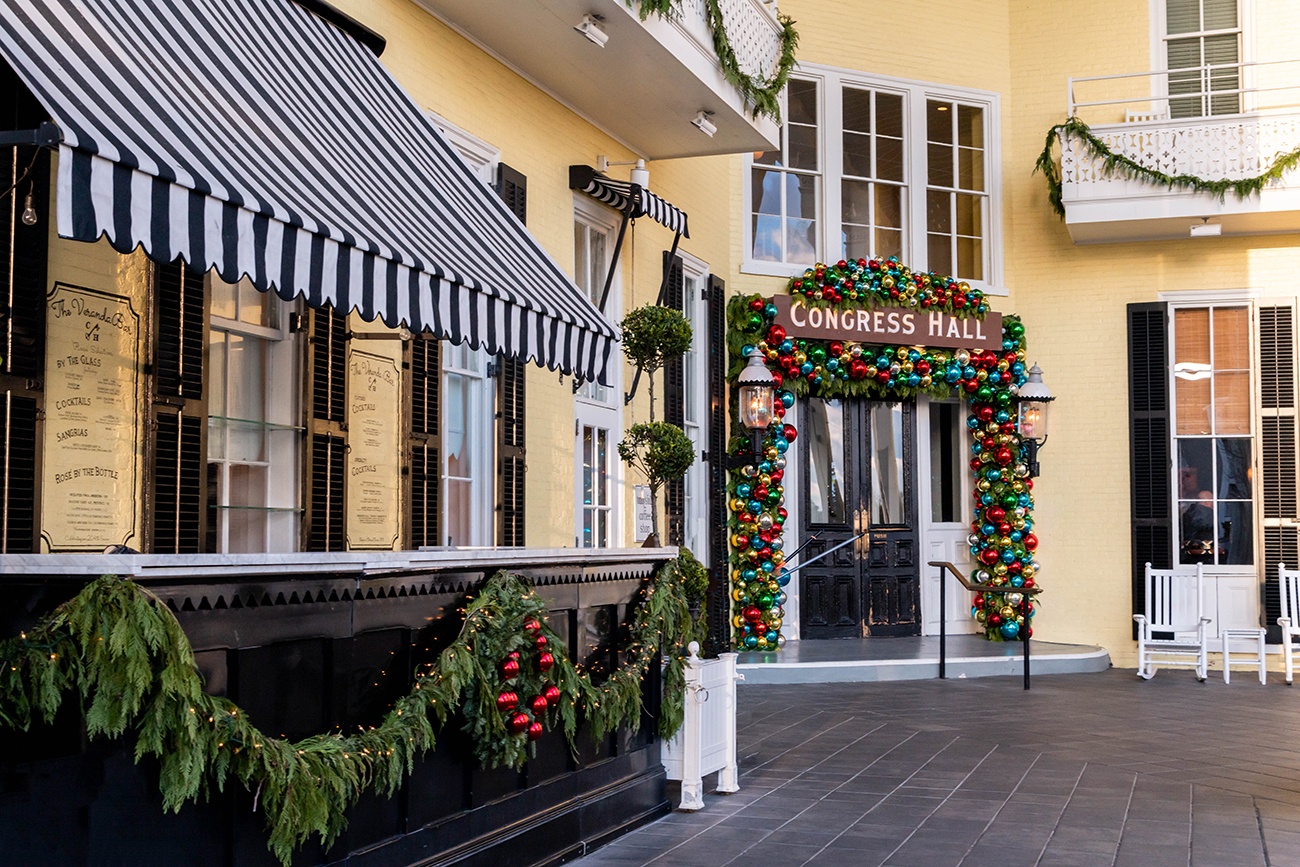 Evergreen garland and red, blue, gold, and silver Christmas bulbs hung around the door and outside bar at Congress Hall