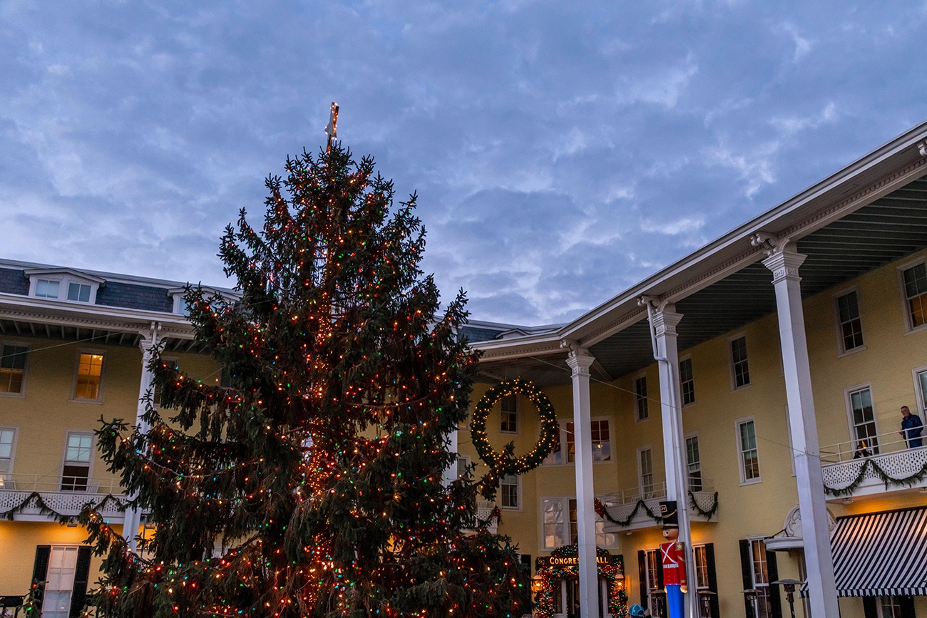 A Christmas tree with colorful lights in front of Congress Hall during the early evening