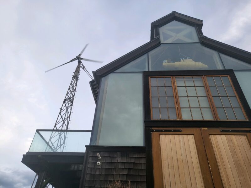 The upper floors of a house on the harbor with a windmill and yellow submarine visible through the windows