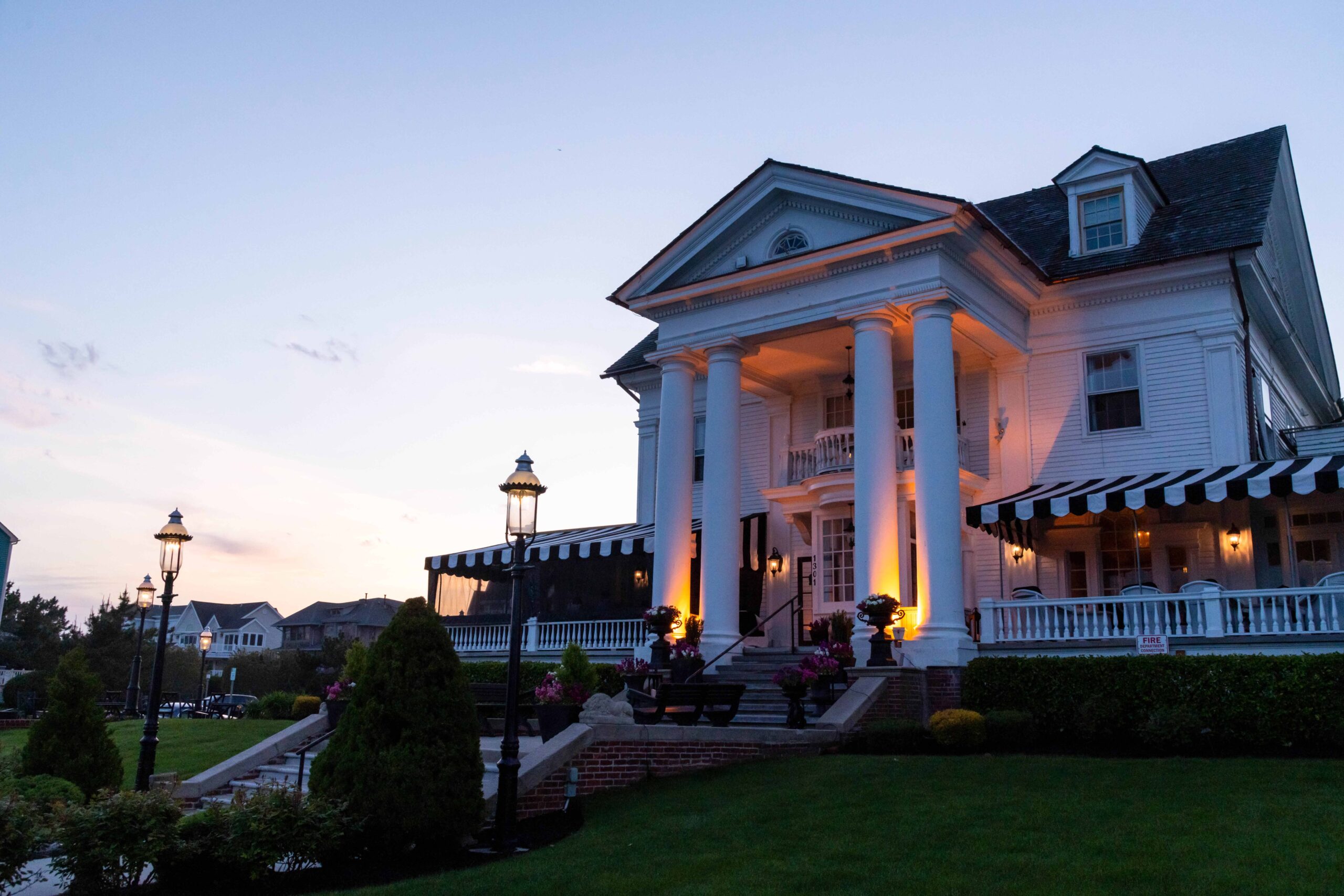 Peter Shields Inn, a Victorian style white restaurant and bed and breakfast, with lights on just after sunset