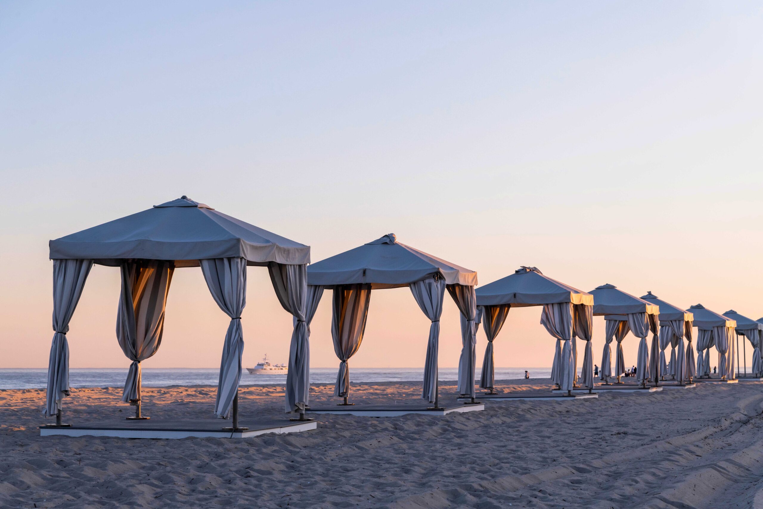 Beach cabanas lined up in a row at sunset