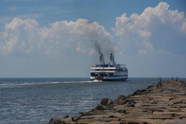 The Ferry heading out while fishermen are on the jetty