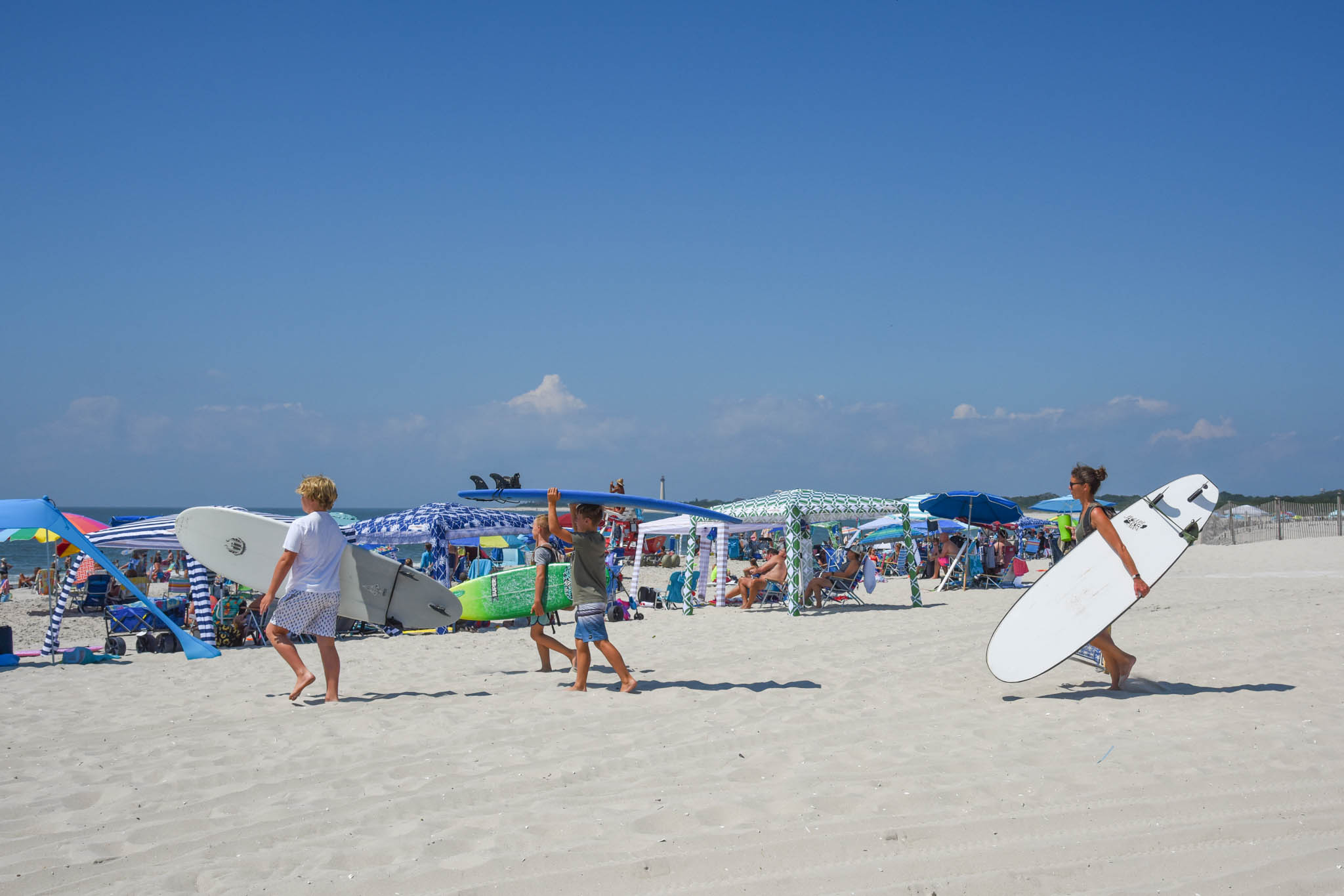 A family head to the beach with surfboards at the Cove.