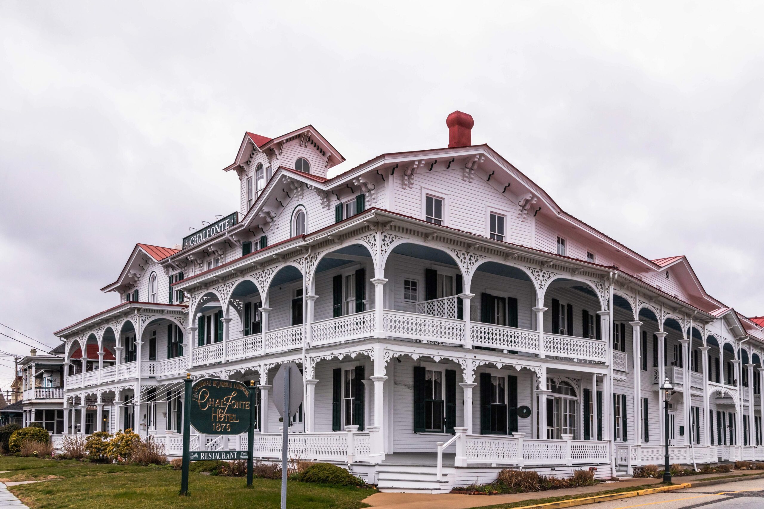 The Chalfonte Hotel, a white and green Victorian style building, with clouds in the sky