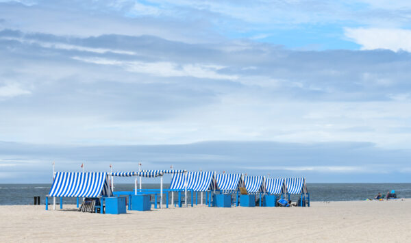 Blue and white cabanas with an white and blue sky