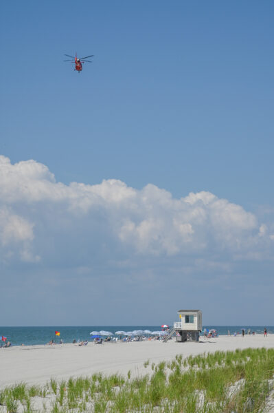 Wave to the USCG Helicopter as it flies over the beach